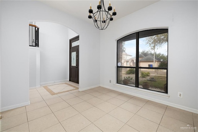 unfurnished room with light tile patterned floors and a chandelier