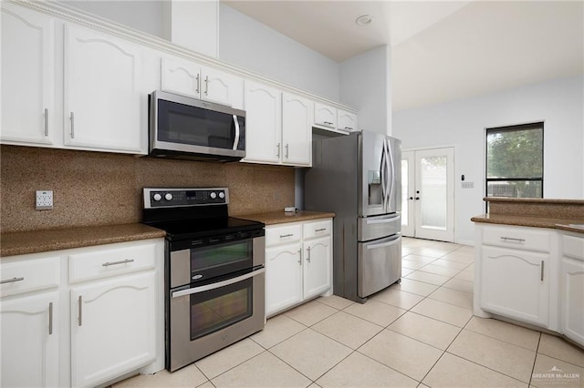 kitchen with backsplash, white cabinets, and stainless steel appliances