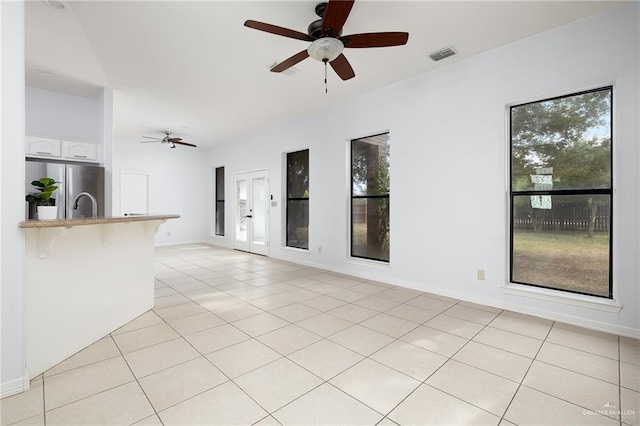 unfurnished living room with ceiling fan and light tile patterned floors