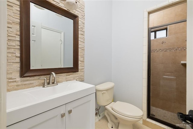 bathroom featuring toilet, a shower with shower door, and vanity