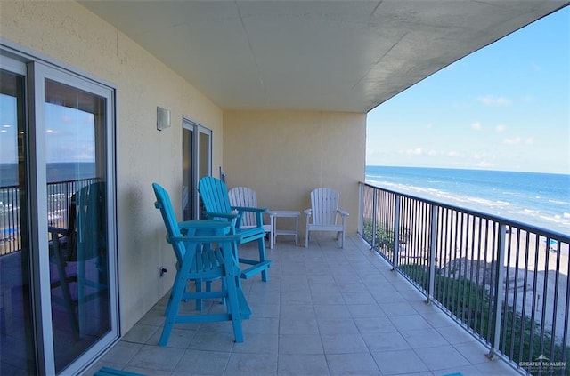 balcony featuring a water view and a beach view