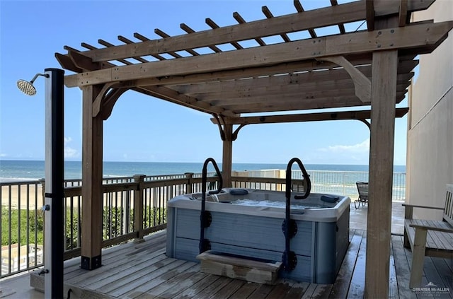 wooden terrace featuring a view of the beach, a water view, a pergola, and a hot tub