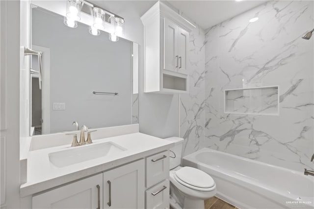 full bathroom featuring tiled shower / bath combo, vanity, and toilet