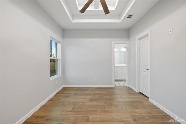 spare room featuring ceiling fan and a raised ceiling