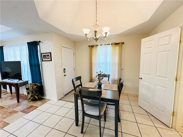 tiled dining space featuring plenty of natural light, lofted ceiling, and a chandelier