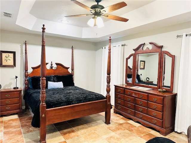 bedroom featuring a tray ceiling and ceiling fan