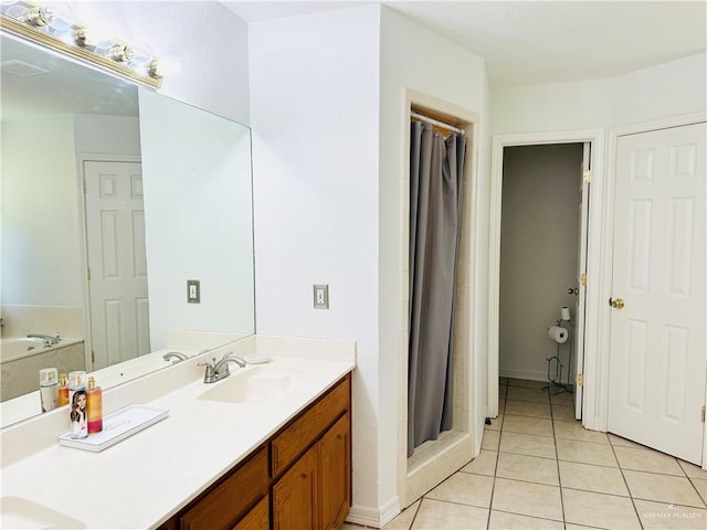 bathroom with tile patterned floors, vanity, and walk in shower