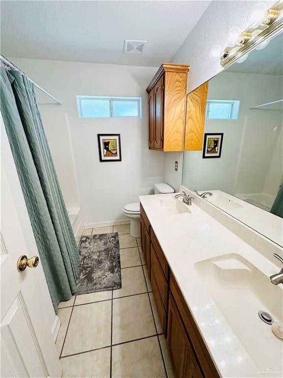 full bathroom featuring tile patterned floors, vanity, shower / bath combination with curtain, and toilet