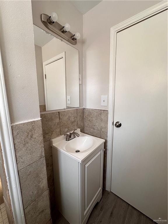 bathroom with vanity, wood-type flooring, and tile walls