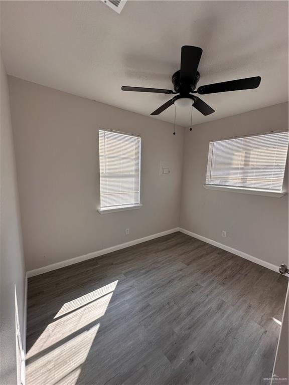 empty room featuring ceiling fan and dark wood-type flooring