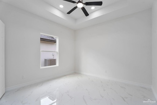 unfurnished room featuring ceiling fan and a tray ceiling