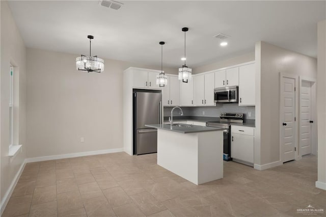 505 E Hawk Ave E, Pharr, TX 78577 - kitchen featuring stainless steel appliances, decorative backsplash, dark countertops, white cabinetry, and hanging light fixtures