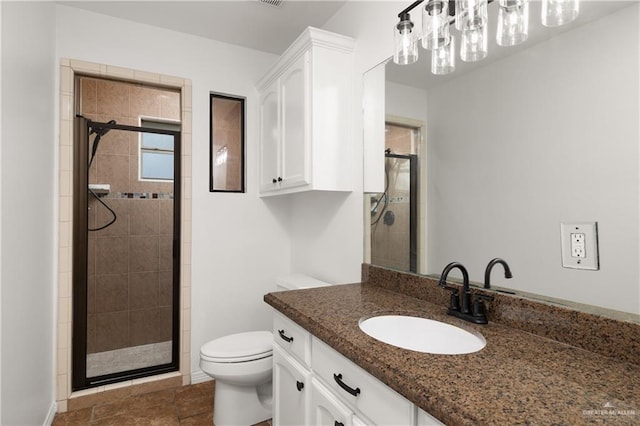 bathroom featuring an enclosed shower, vanity, and toilet