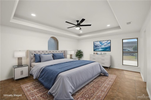 bedroom featuring ceiling fan and a tray ceiling