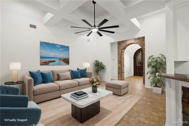 living room featuring beamed ceiling and ceiling fan