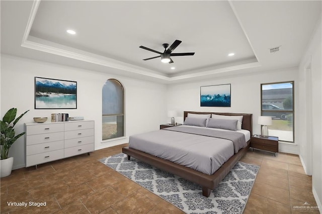 bedroom with ceiling fan and a tray ceiling