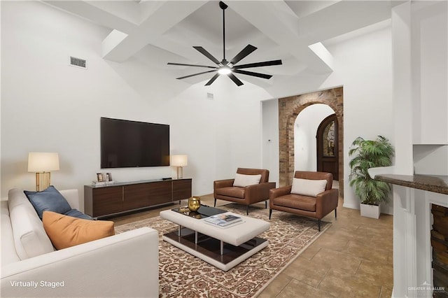 living room with beamed ceiling, coffered ceiling, and ceiling fan