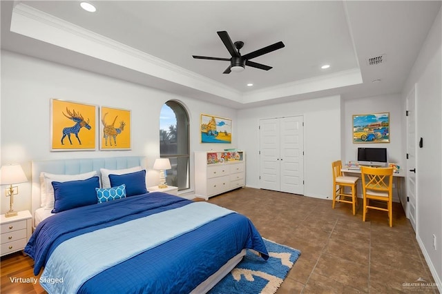 bedroom with ceiling fan, ornamental molding, a raised ceiling, and a closet