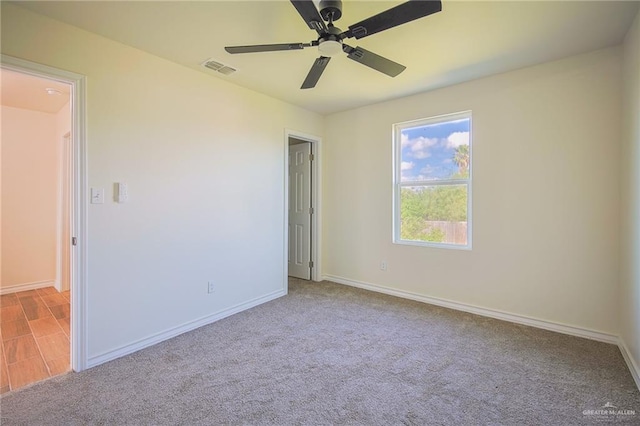 unfurnished room with light colored carpet and ceiling fan