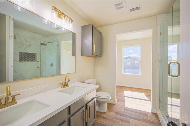 bathroom with vanity, toilet, and a shower with shower door