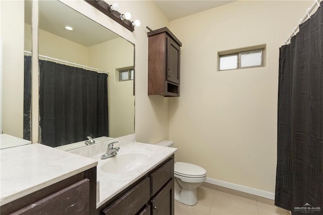 bathroom with baseboards, toilet, vanity, and tile patterned floors