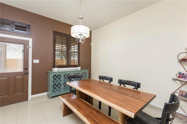 dining space with a healthy amount of sunlight, an inviting chandelier, light tile patterned floors, and baseboards