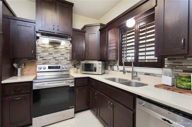 kitchen featuring decorative backsplash, appliances with stainless steel finishes, light countertops, under cabinet range hood, and a sink