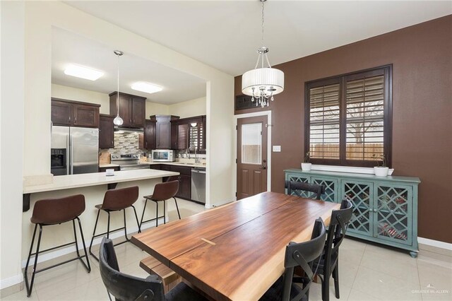 dining space featuring light tile patterned flooring and baseboards