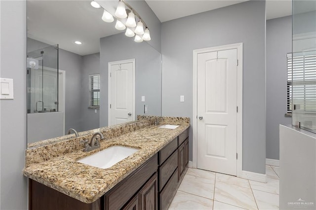 8605 Estrella Dr, Elsa, TX 78538 - full bath featuring an enclosed shower, double vanity, baseboards, and a sink