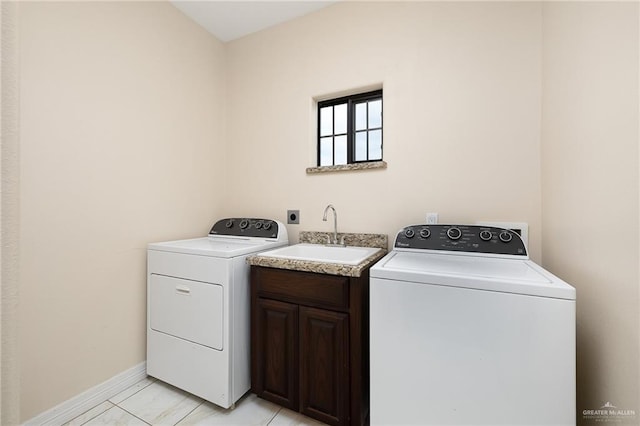 8605 Estrella Dr, Elsa, TX 78538 - clothes washing area with cabinet space, baseboards, a sink, and washing machine and clothes dryer