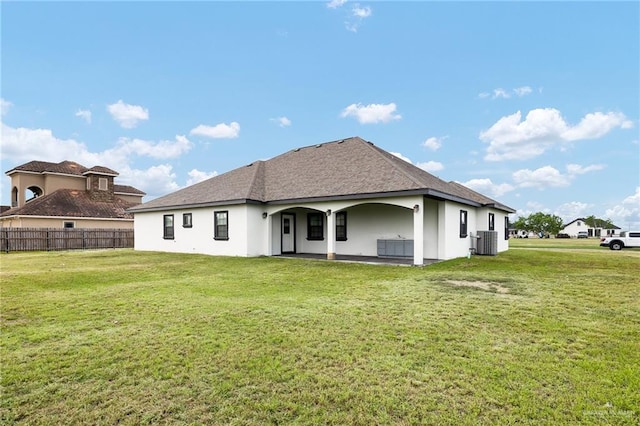 8605 Estrella Dr, Elsa, TX 78538 - rear view of property with central air condition unit, a lawn, fence, and stucco siding