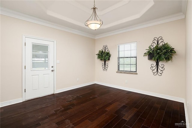 8605 Estrella Dr, Elsa, TX 78538 - empty room with baseboards, a raised ceiling, crown molding, and dark wood finished floors