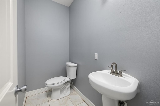8605 Estrella Dr, Elsa, TX 78538 - half bathroom with a sink, baseboards, toilet, and marble finish floor