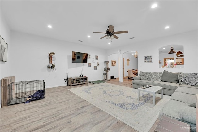 living room with ceiling fan, arched walkways, wood finished floors, and recessed lighting