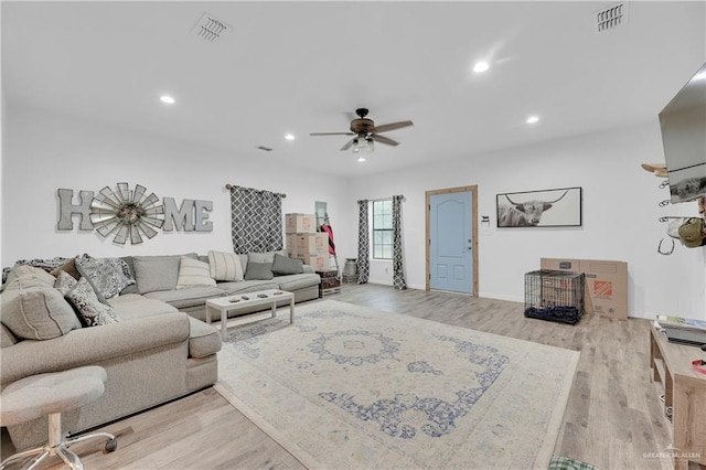 living area with a ceiling fan, recessed lighting, visible vents, and light wood finished floors