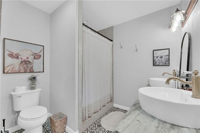 full bathroom with a shower with shower curtain, a sink, toilet, and baseboards