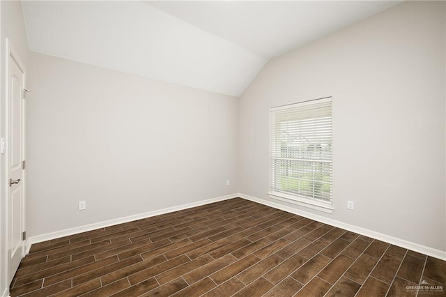 empty room with vaulted ceiling and dark hardwood / wood-style floors