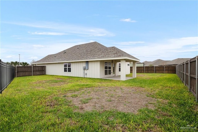 back of house with a yard and a patio