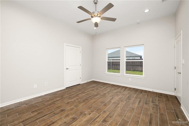 spare room with dark hardwood / wood-style flooring and ceiling fan