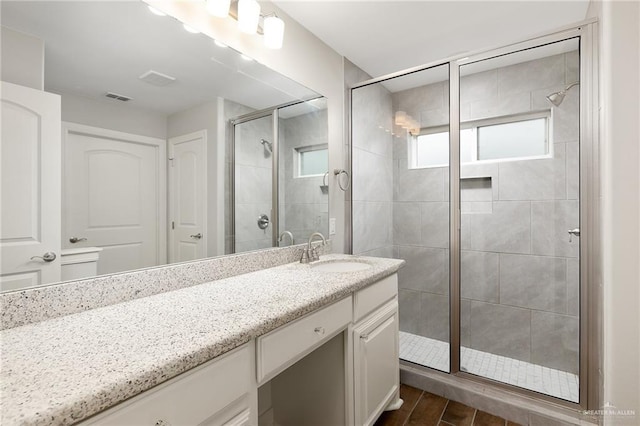 bathroom featuring walk in shower and vanity