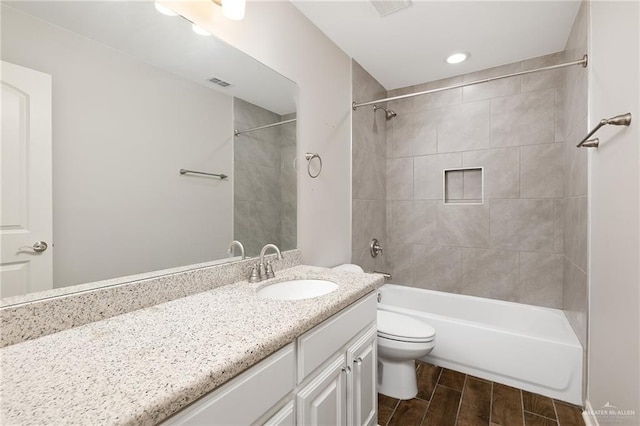 full bathroom featuring vanity, toilet, and tiled shower / bath combo