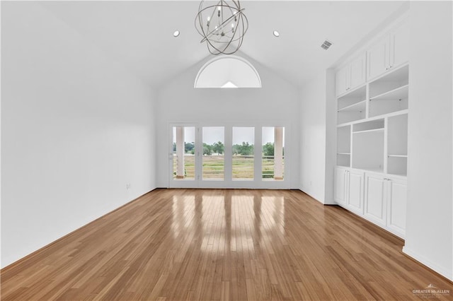 412 Sabine Ct, Mission, TX 78572 - unfurnished living room with a chandelier, light wood-style floors, high vaulted ceiling, and built in shelves