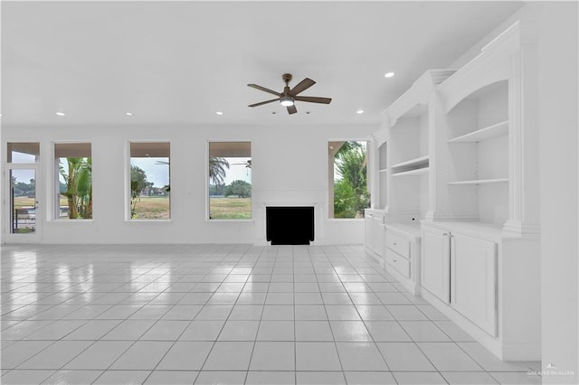 412 Sabine Ct, Mission, TX 78572 - unfurnished living room with light tile patterned floors, a ceiling fan, a fireplace, recessed lighting, and built in shelves