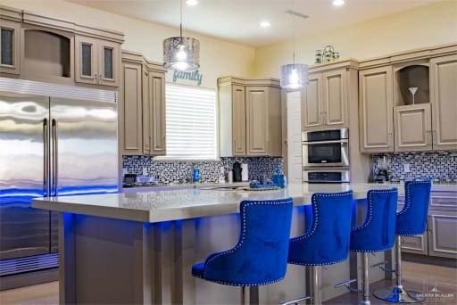 kitchen with a kitchen bar, decorative light fixtures, appliances with stainless steel finishes, and a center island