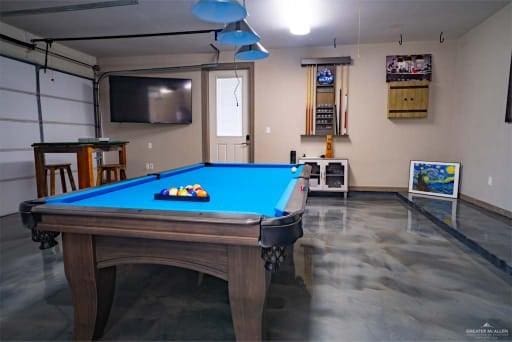 rec room with pool table, a garage, baseboards, and finished concrete floors