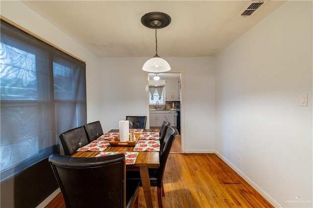 dining area with light wood-type flooring and sink