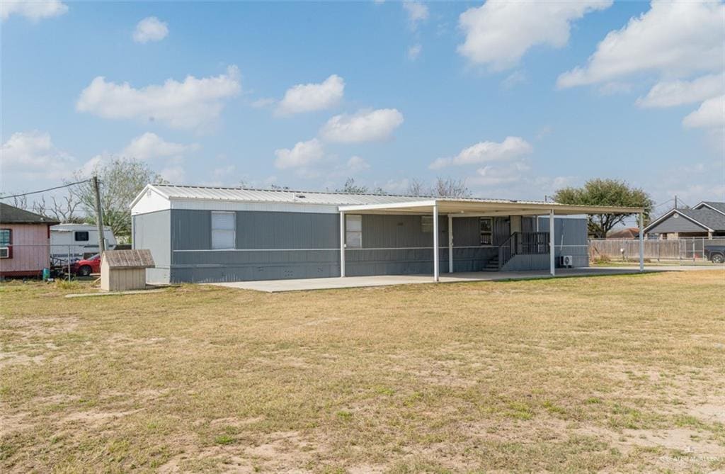 rear view of house featuring a lawn and a sunroom