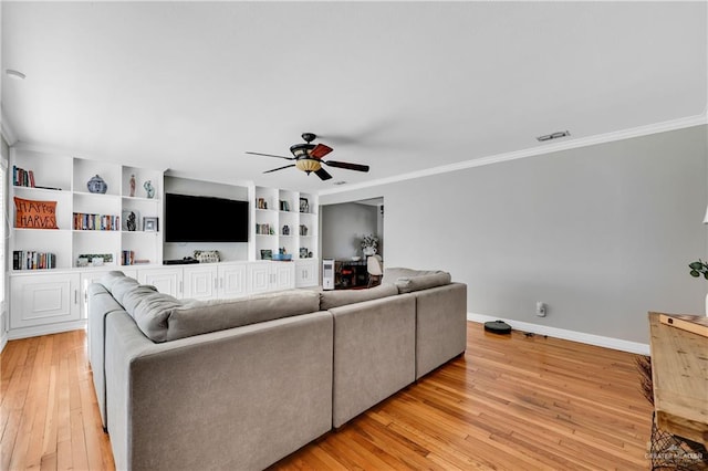 living room featuring light hardwood / wood-style floors, built in features, crown molding, and ceiling fan