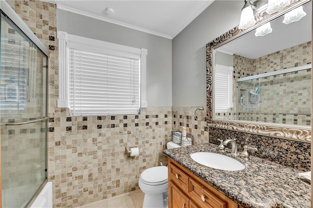 full bathroom with toilet, tile patterned flooring, tile walls, crown molding, and vanity