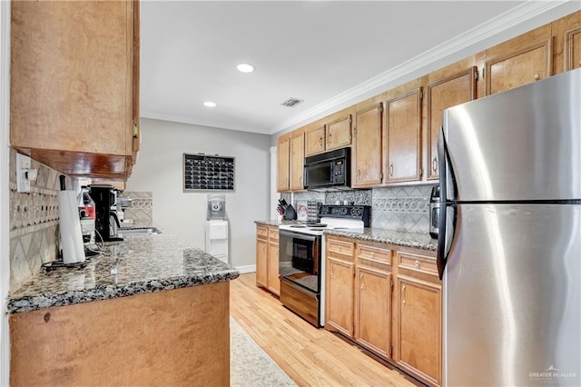 kitchen with decorative backsplash, dark stone counters, stainless steel refrigerator, and electric range oven